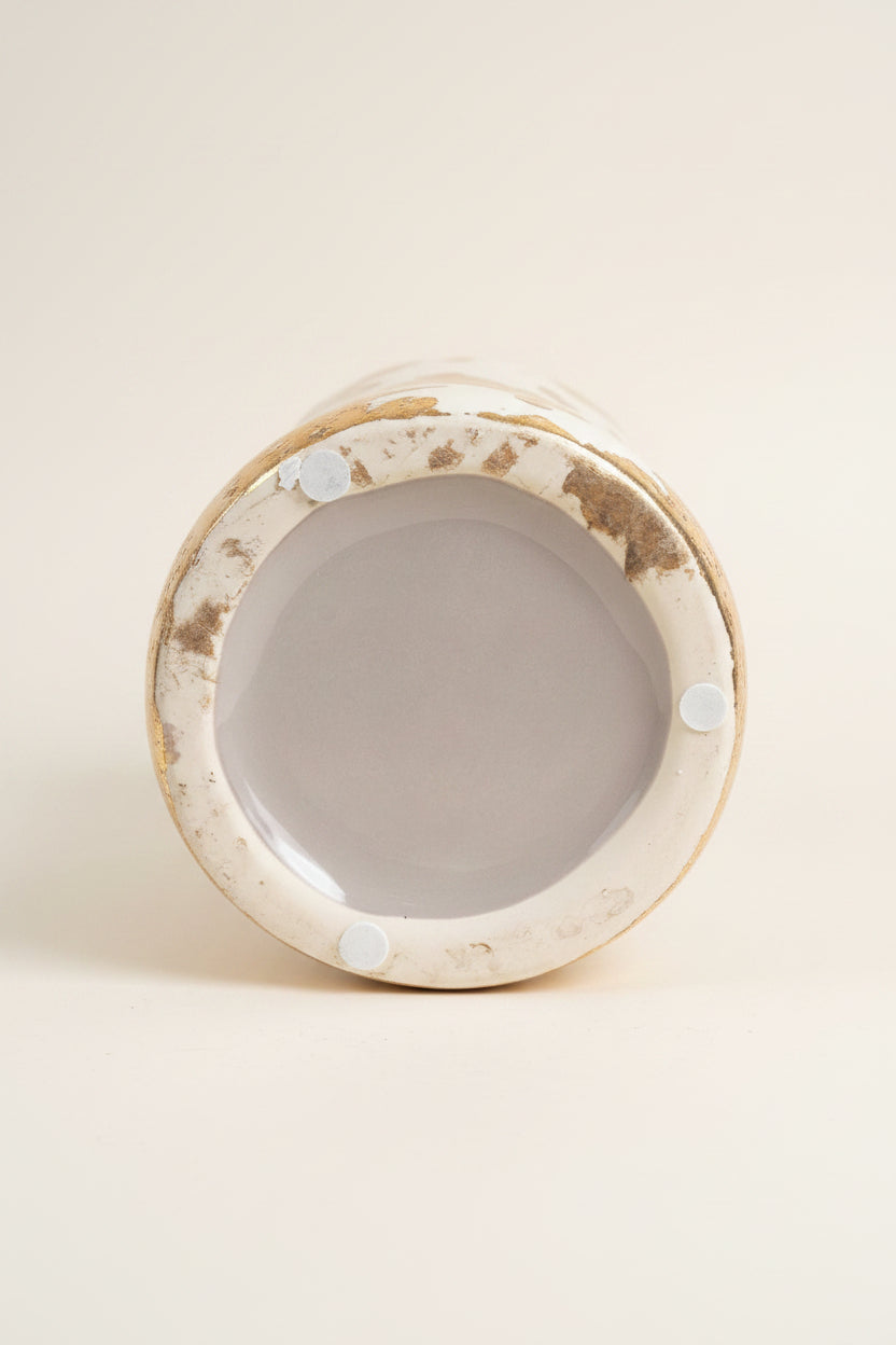 A bottom view of a glossy ceramic abstract face vase showing normal wear consistent with use. 