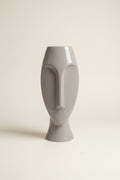 Photo of a Pier 1 abstract face vase against an ivory backdrop. 